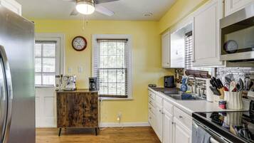 A kitchen with a refrigerator, microwave, stove, and cabinets.