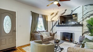 A living room with a fireplace, a ceiling fan, and a large window with curtains. - Fenced Yard! Quiet Home, 3 Mi to Dtwn El Paso (El Paso)