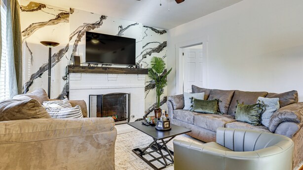 A living room with a fireplace, a flat-screen TV, a sofa, and a coffee table. - Fenced Yard! Quiet Home, 3 Mi to Dtwn El Paso (El Paso)