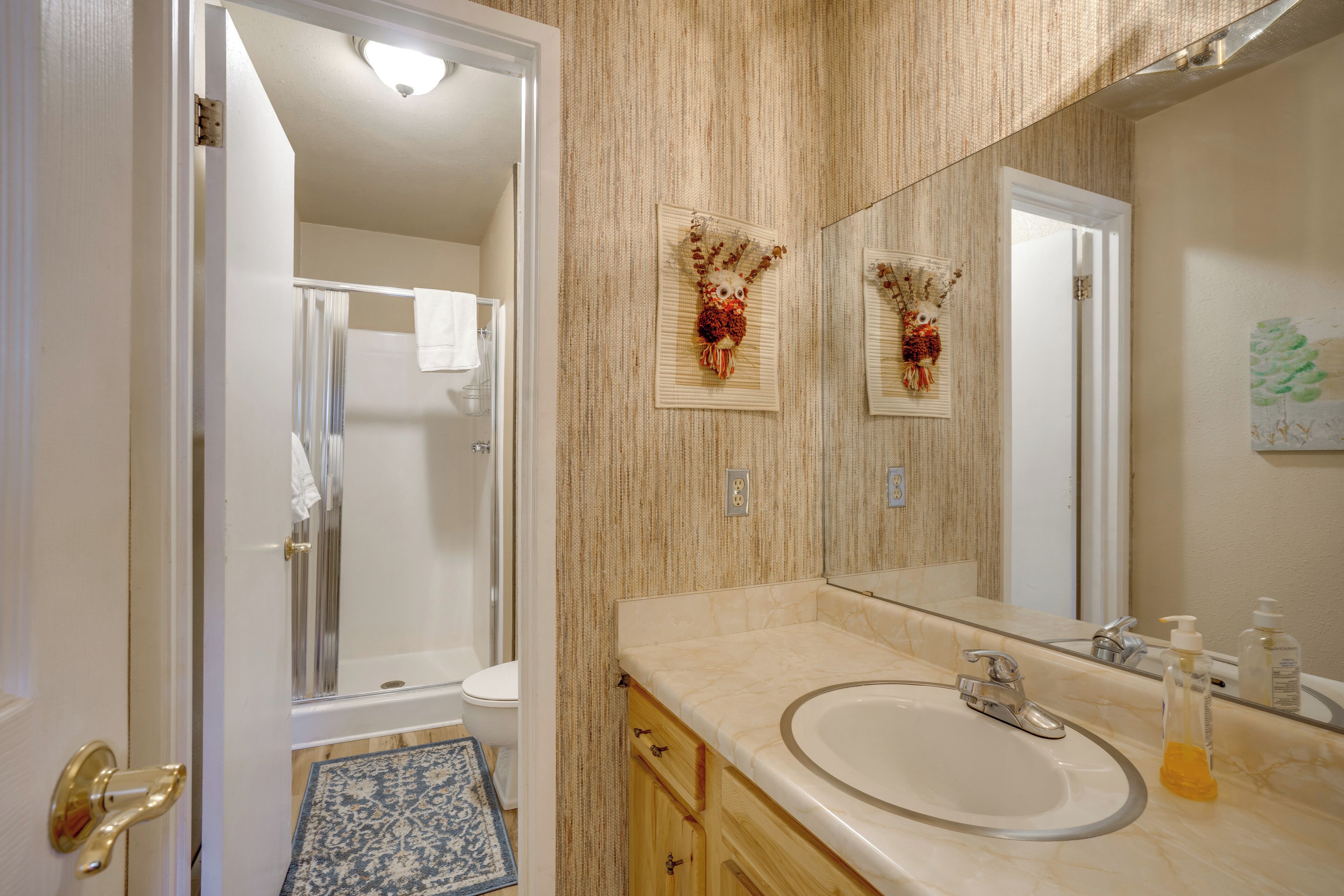 Une salle de bain avec un lavabo, un miroir et un porte-serviettes.
