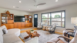 A living room with a sofa, chairs, a coffee table, a TV, and a bookshelf. - Waterfront 2-unit Combo w/ Dock in Dickinson (Dickinson)