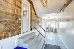 Una escalera con un muro de madera, un letrero de bienvenida y una señal con la letra 'J' en la pared.