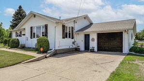 Ein eingeschossiges Haus mit Garage, einer Veranda und einer Auffahrt.