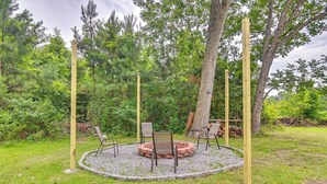 A circular seating area with a fire pit, surrounded by a gravel ring, and four wooden posts. - Walk to Park! Family Retreat w/ Yard in Lumberton (Lumberton)