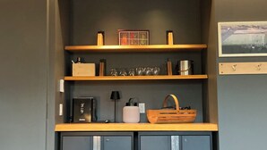 A kitchenette with a coffee machine, a kettle, and a small cabinet.