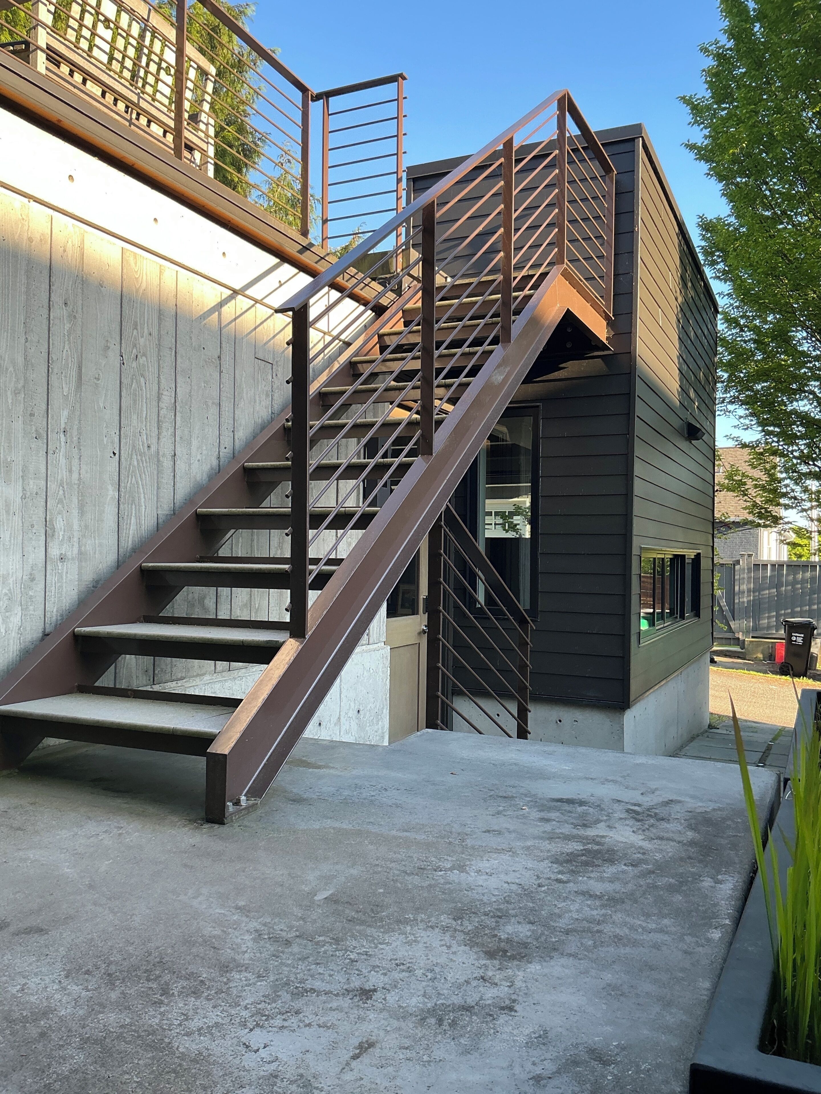 A modern building with a staircase leading to a second-floor balcony.