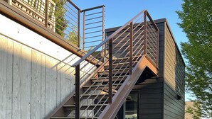 A modern building with a staircase leading to a second-floor balcony.