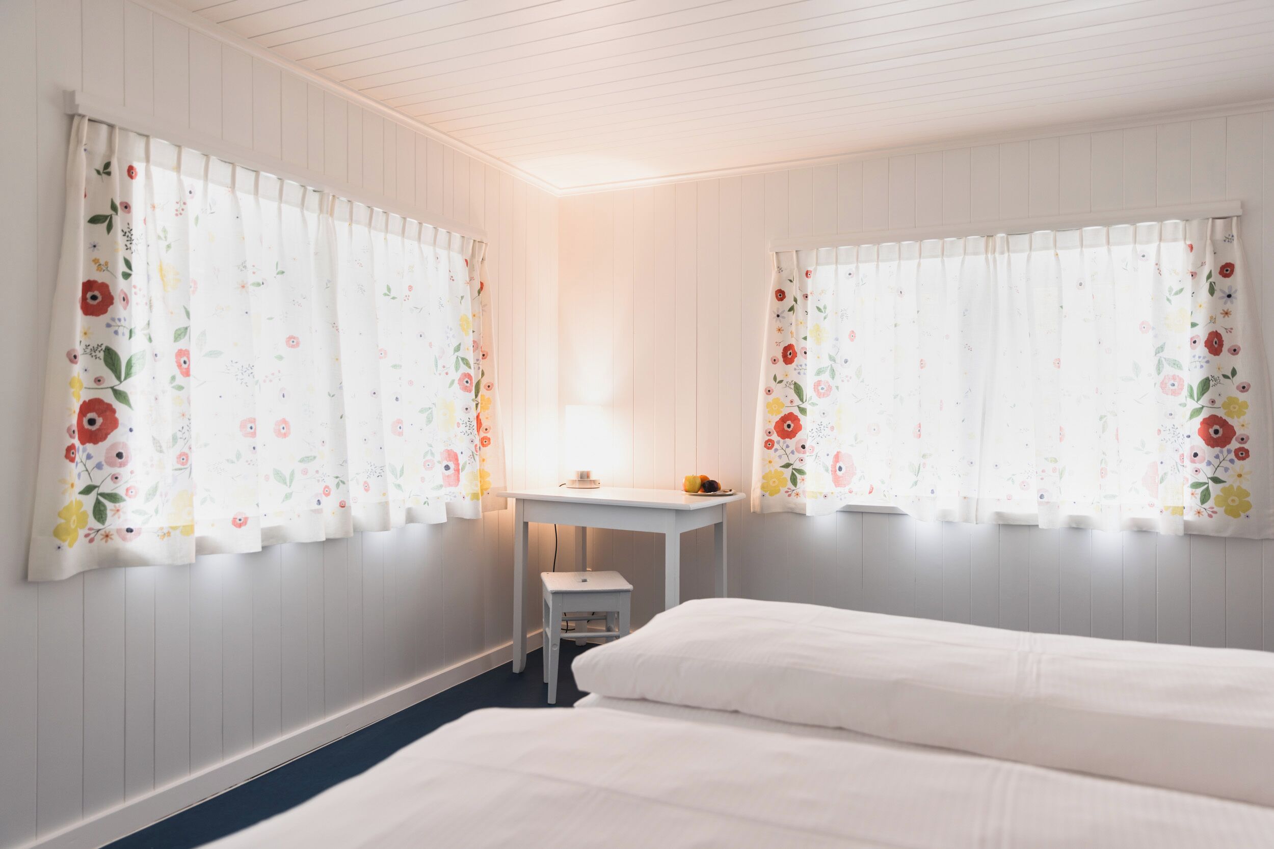 Ein Schlafzimmer mit zwei Betten, einem kleinen Tisch und einem Stuhl.