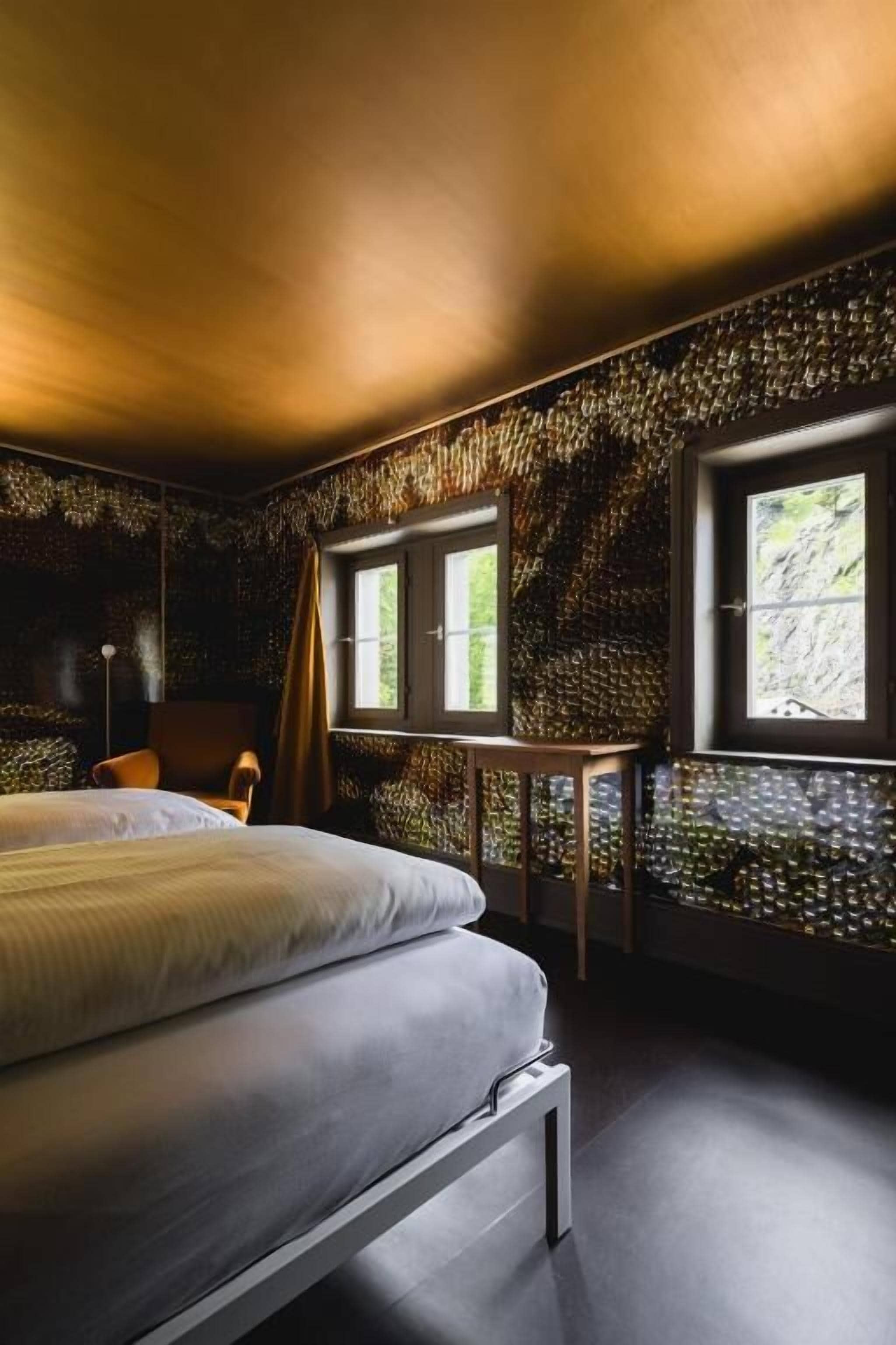 A bedroom with a bed, a desk, and a window.