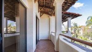 Un couloir doté d’un sol carrelé, de murs blancs et d’un plafond en bois.