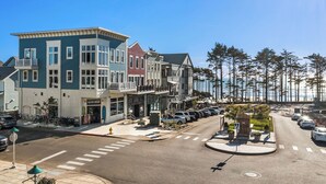 Una strada costiera con edifici a più piani, un'area di parcheggio e vista sull'oceano.