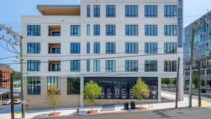A modern multi-story building with a flat roof, large windows, and a sign for 'GSBEE Apartments'. - Landing Spectacular Studio, Gym, Pool (Durham)