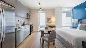 A compact hotel room with a kitchenette, a dining area, and a bed. - Landing Spectacular Studio, Gym, Pool (Durham)