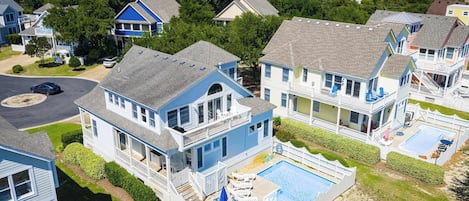 Área residencial com casas, piscina e vista para o oceano.
