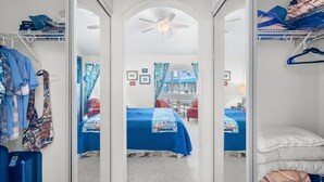 Ein Hotelzimmer mit Bett, Deckenventilator, Kleiderschrank und Blick ins Freie.
