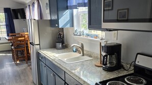 A kitchen with a stove, sink, and cabinets. - Tiny Home Walking Distance to the Beach (Port O`Connor)