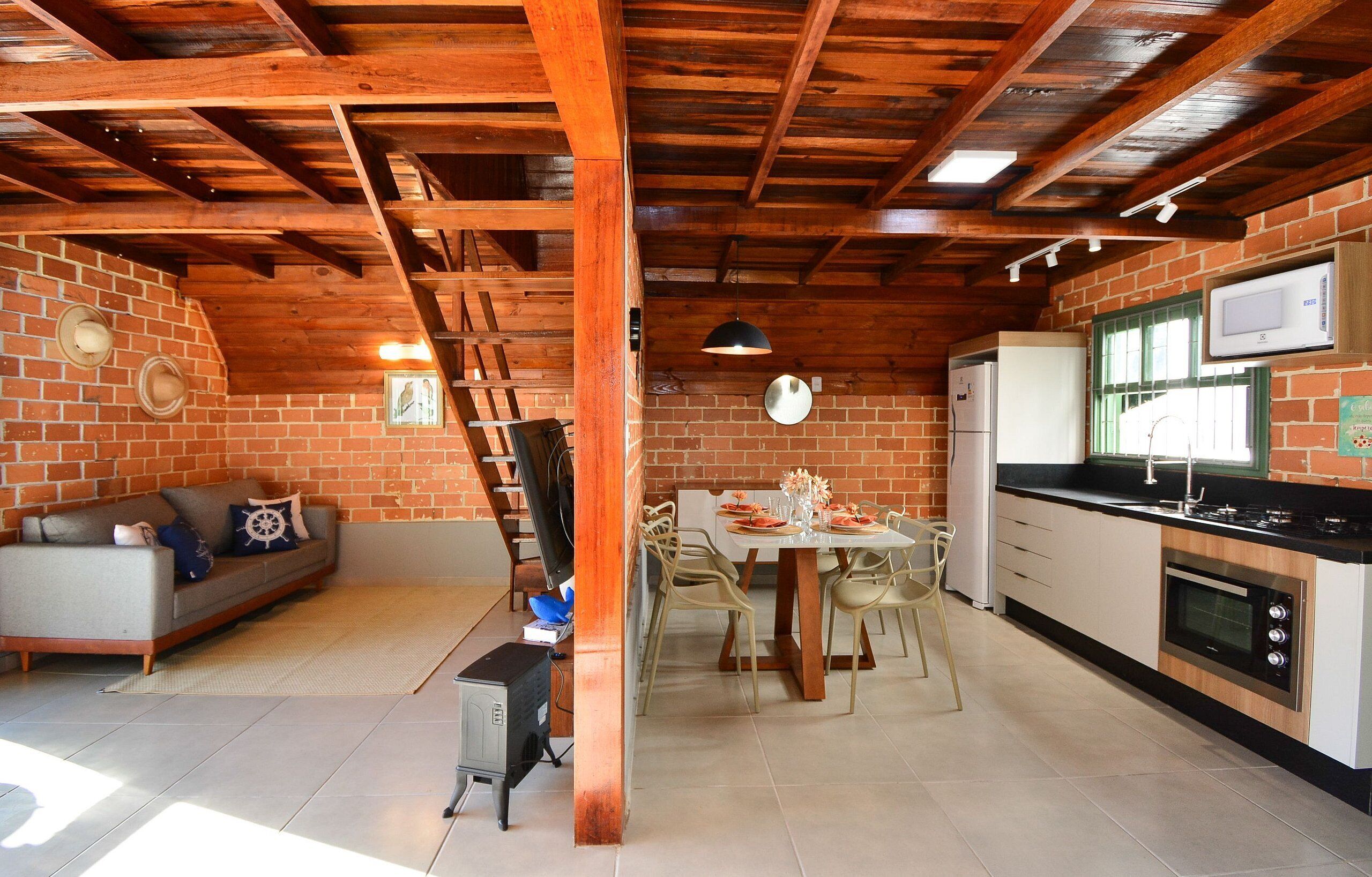 Una cocina con una mesa de comedor y sillas, un refrigerador y un microondas.