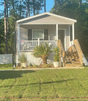 A single-story house with a front porch, a 'Hello' sign, and a 'Warning: Security Cameras in Use' sign. - Great Escape! Beautiful 2-bedroom house in friendly Perdido Key. Pet friendly! (Pensacola)
