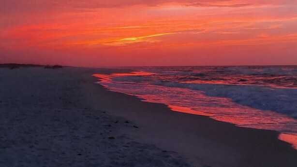Una spiaggia con onde al tramonto.