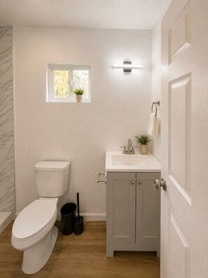 Ein Badezimmer mit Toilette, Waschbecken und Fenster.