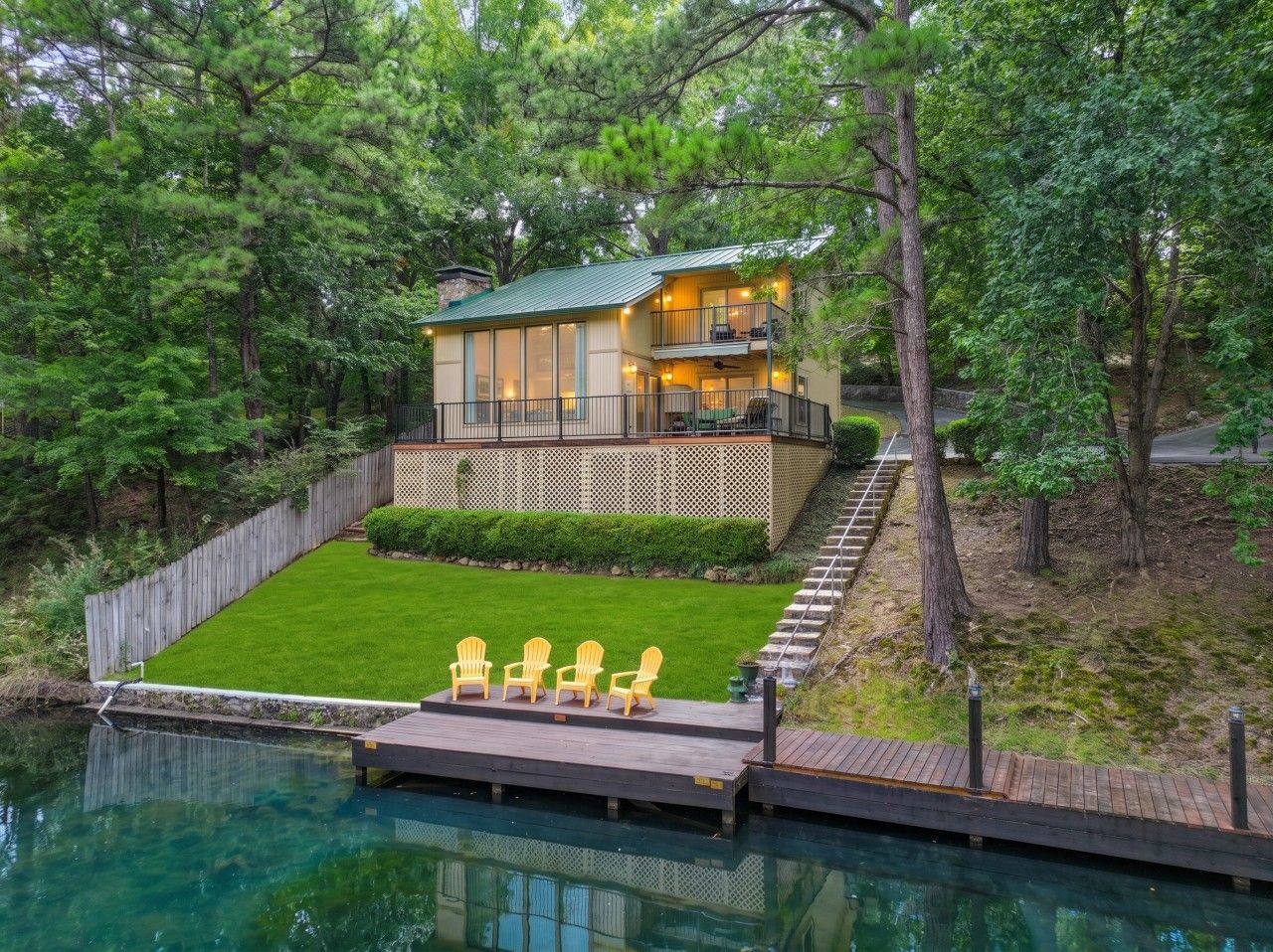 A two-story house with a deck and a swimming pool.