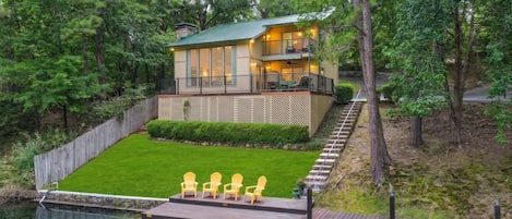 A two-story house with a deck and a swimming pool.