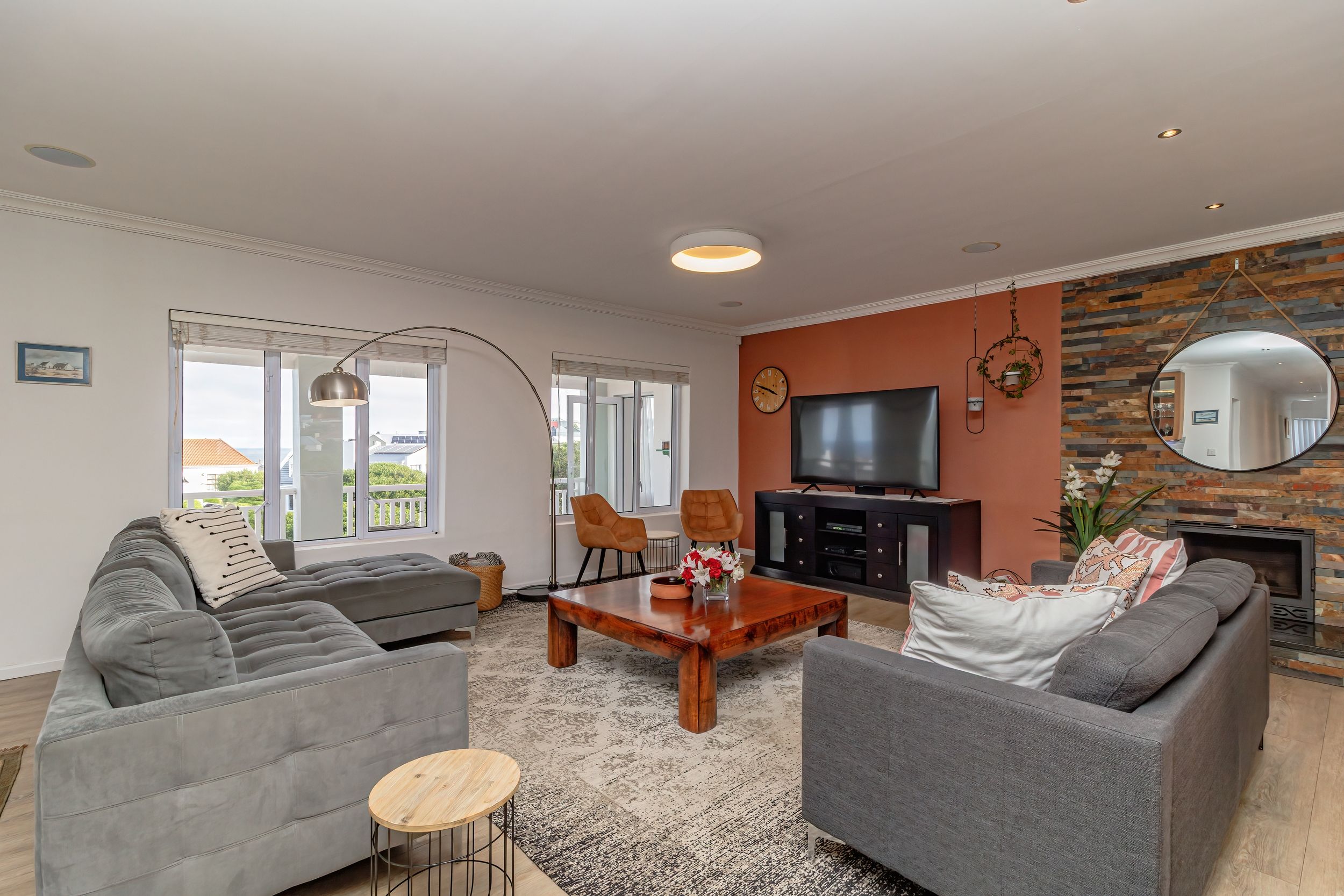 A modern living room with two grey sofas, a coffee table, and a TV.