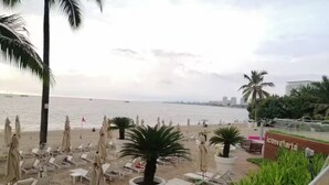 A beachside hotel with sun loungers, umbrellas, and a view of the sea. - Icon Vallarta 2-2501, 1 bedroom with ocean view (Puerto Vallarta)