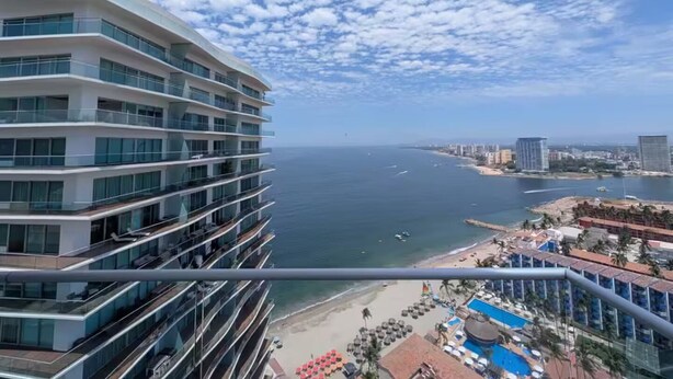 A high-rise hotel with multiple balconies overlooking a beach and ocean. - Icon Vallarta 2-2501, 1 bedroom with ocean view (Puerto Vallarta)