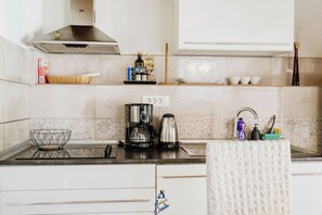 Eine Küche mit Kaffeemaschine, Wasserkocher und einem Korb auf der Arbeitsfläche.