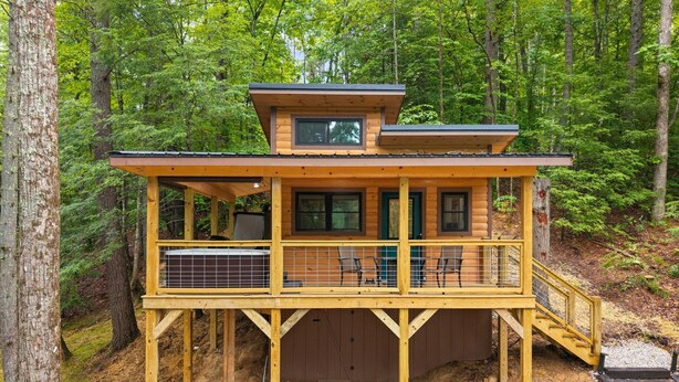 A wooden cabin with a balcony, surrounded by trees. - Whitney Nook: The Ultimate Cozy & Connected Couples’ Hideaway (Campton)