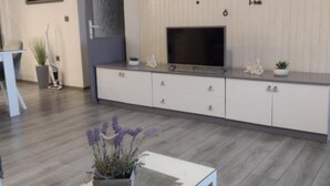 A modern kitchen with a built-in TV, white cabinetry, and a grey countertop. - Mare`s Home (Sibenik)