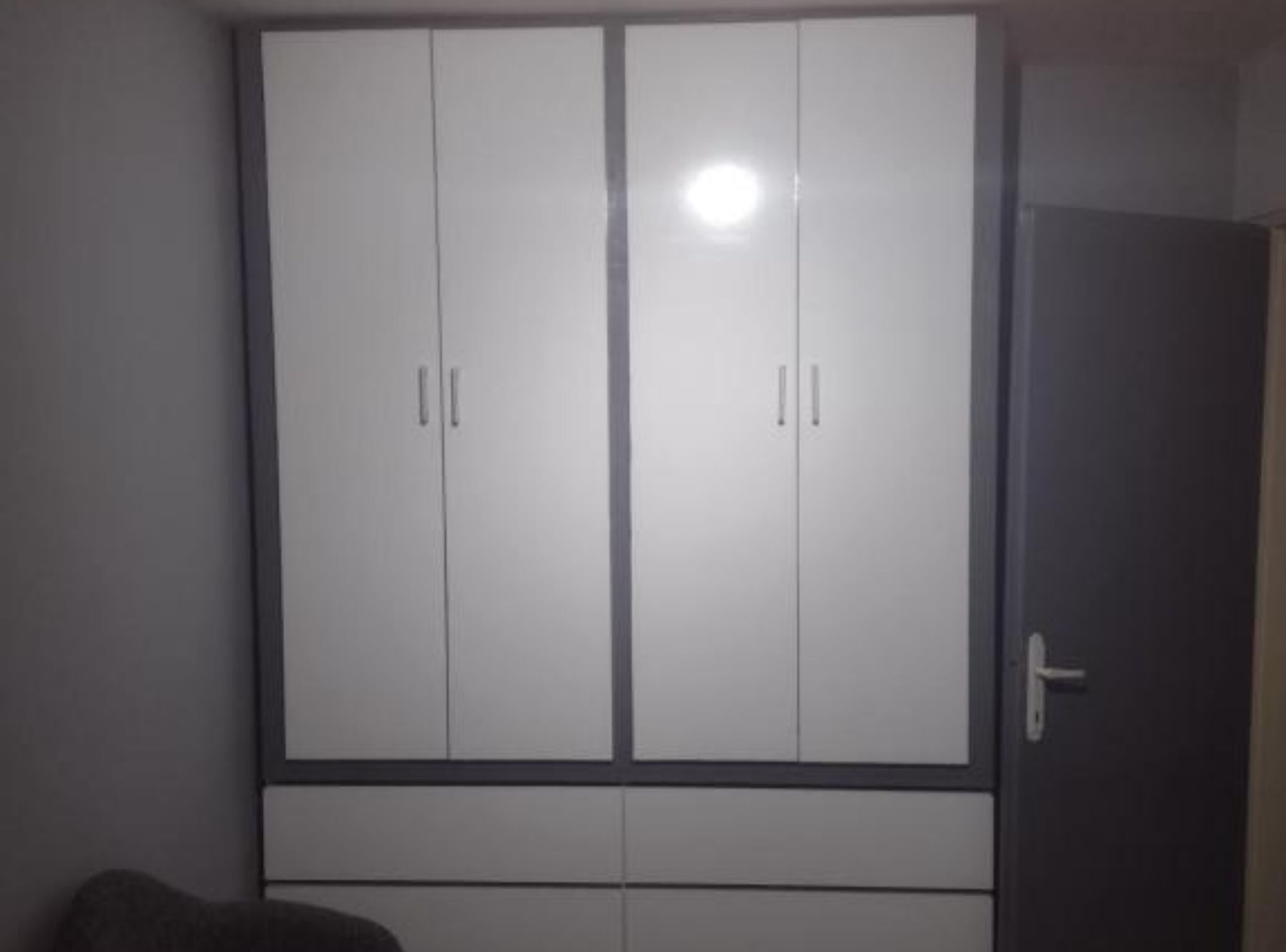 Un armario con dos puertas y una repisa inferior.