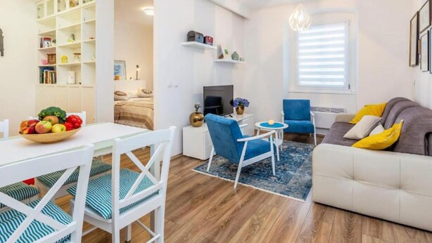 A modern living room with a dining area, a sofa, a TV, and a bookshelf. - Apartment Sabo (Rijeka)