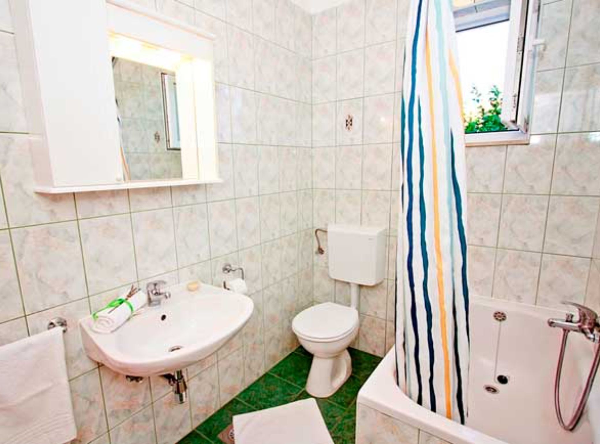 A bathroom with a sink, toilet, and bathtub.