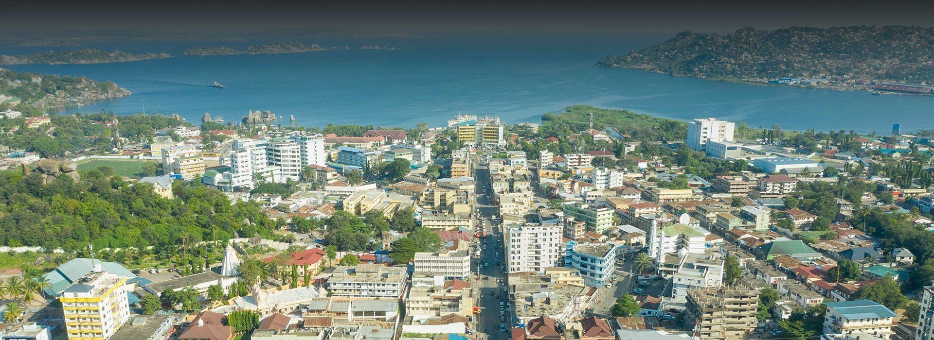 A coastal cityscape with dense urban development, including various building types and a prominent body of water.