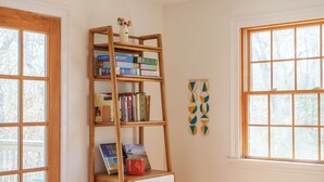 Ein Zimmer mit einer Ledersofa, einem Holzbücherregal und einem Fenster mit Blick.