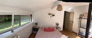 A bedroom with a bed, a window, a bedside table, a lamp, a hanging light, and a wardrobe. - Beautiful, spacious villa—perfect for a summer vacation for 5–6 people - (Le Rouret)