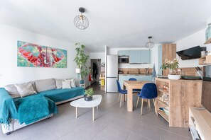 Ein modernes Wohnzimmer mit einer Couch, einem Couchtisch und einem Essbereich mit Stühlen.
