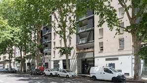 A multi-story building with a modern architectural design, featuring balconies and large windows. - Carnet de route - Appt climatisé avec balcon (Lyon)