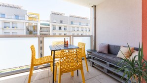 A balcony with yellow chairs, a table, and a sofa. - Carnet de route - Appt climatisé avec balcon (Lyon)