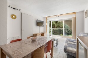 Eine moderne Küche mit Esstisch, Stühlen und einem Fernseher.