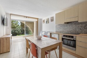 Eine moderne Küche mit Essbereich, großen Fenstern und Blick auf Grünflächen.