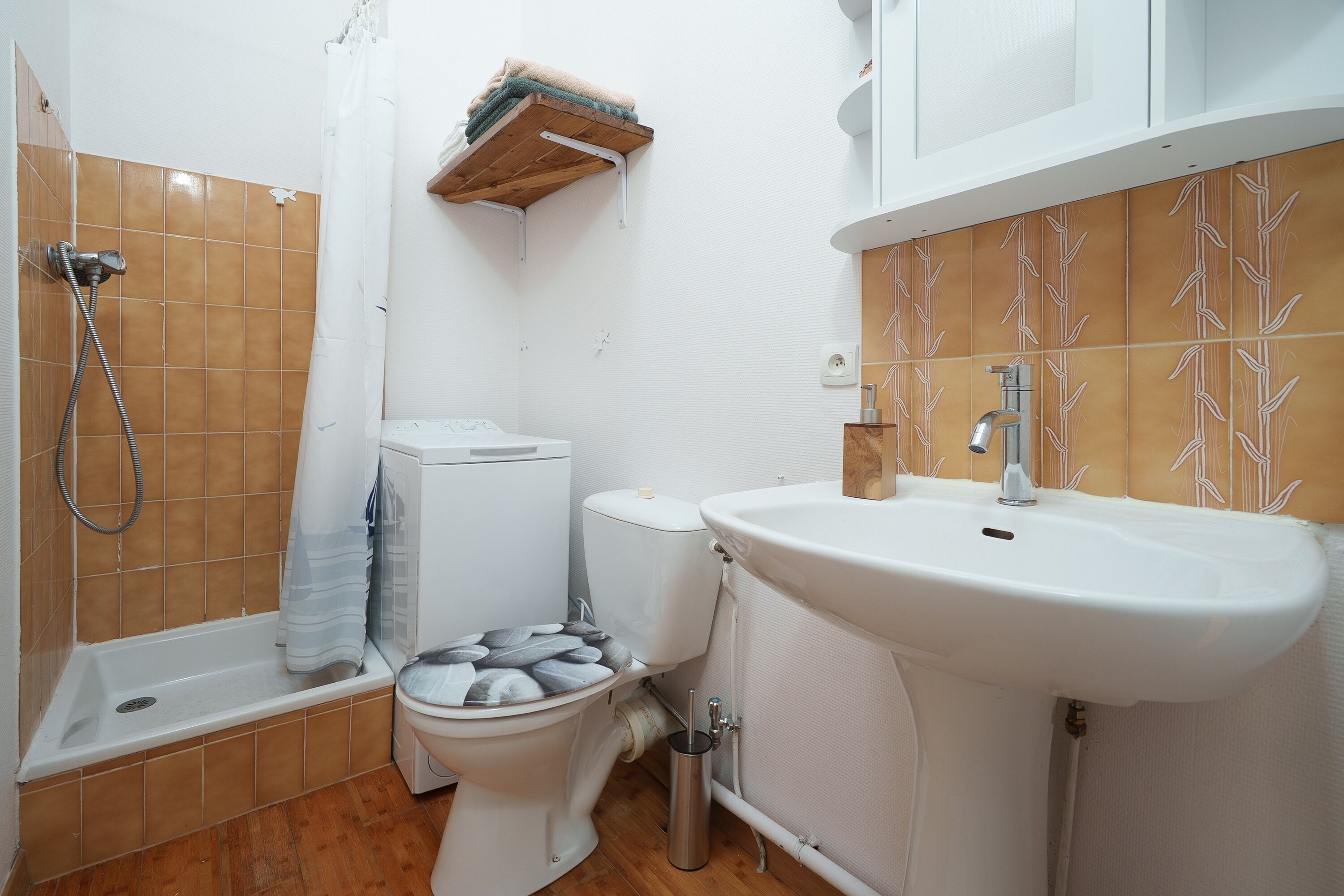 Une salle de bain avec douche, toilettes et lavabo.