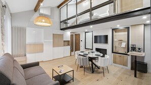 A modern interior with a dining area, sofa, and kitchen. - Le Rempart Duplex - Au coeur du Vieil Antibes (Antibes)