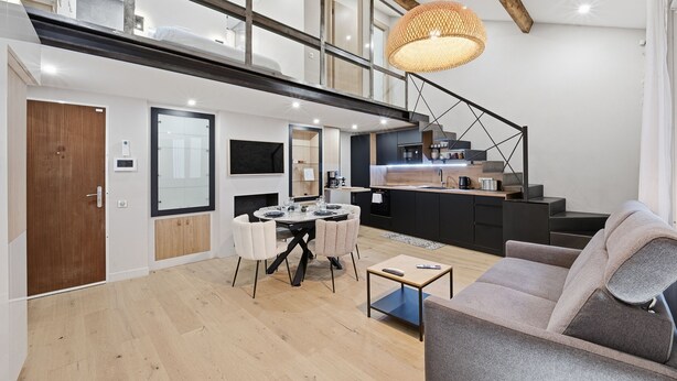 A modern interior with a dining area, kitchen, and staircase. - Le Rempart Duplex - Au coeur du Vieil Antibes (Antibes)