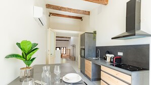 A modern kitchen with a built-in stove, a sink, and a wooden cabinet. - Le Resticas - Triplex climatisé (Rustiques)