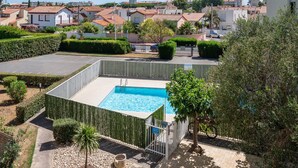 A residential area with a swimming pool, a gated entrance, and a view of neighboring houses. - Le Refuge de Canet - Studio climatisé (Canet-en-Roussillon)
