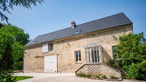 A stone building with a tiled roof, a large window, and a door. - Les Clés de Censibele - Charmant gîte pour 12 (Braye)