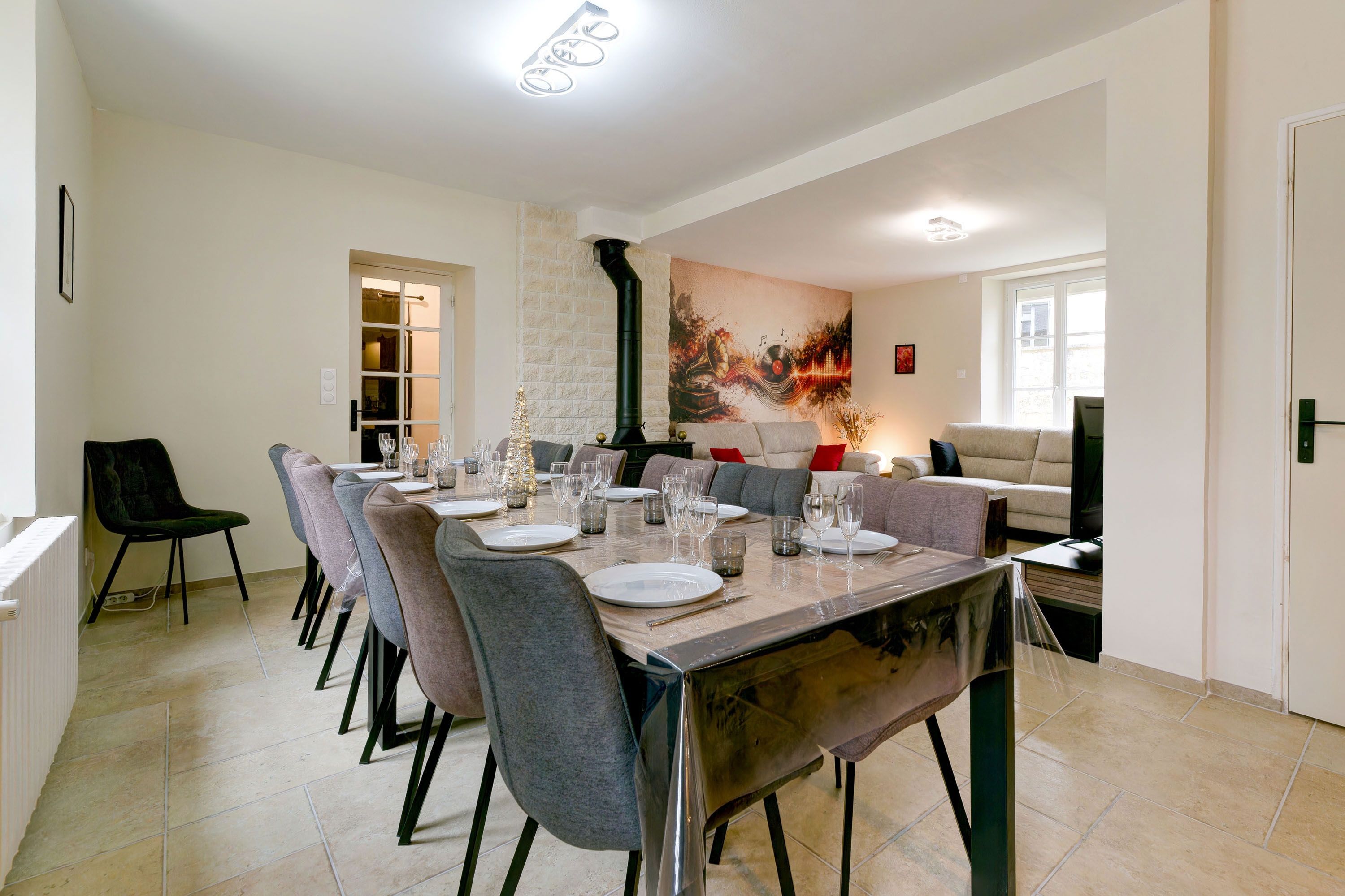 A dining area with a long table set for six, surrounded by chairs.